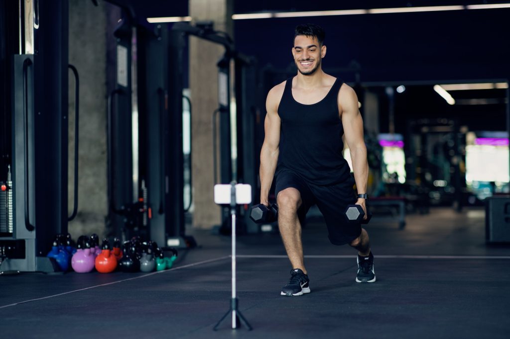 Arab Male Fitness Coach Capturing Training Videos At Gym For His Blog